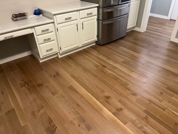 White oak hardwood floors with a natural matte finish installed in a kitchen with white cabinetry and stainless steel refrigerator, professional flooring installation in Somerville, New Jersey