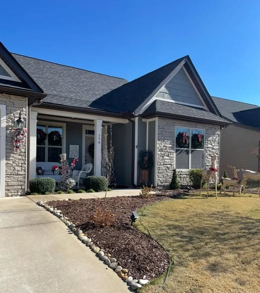 Completed exterior painting of a gray Craftsman-style home with stone accents, dark trim, and holiday decorations, professional exterior painting services in Far Hills, New Jersey